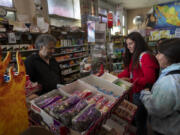 High school girls just off a bus crowd the counter at Stratford Market as owner Mahmod Alrihimi rings up purchases. The market is one of few business open in the struggling Central Valley town.