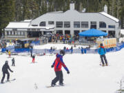 Skiers and snowboarders make their way down the slopes toward Sunrise Lodge at Mt. Bachelor ski area in Oregon in 2019.