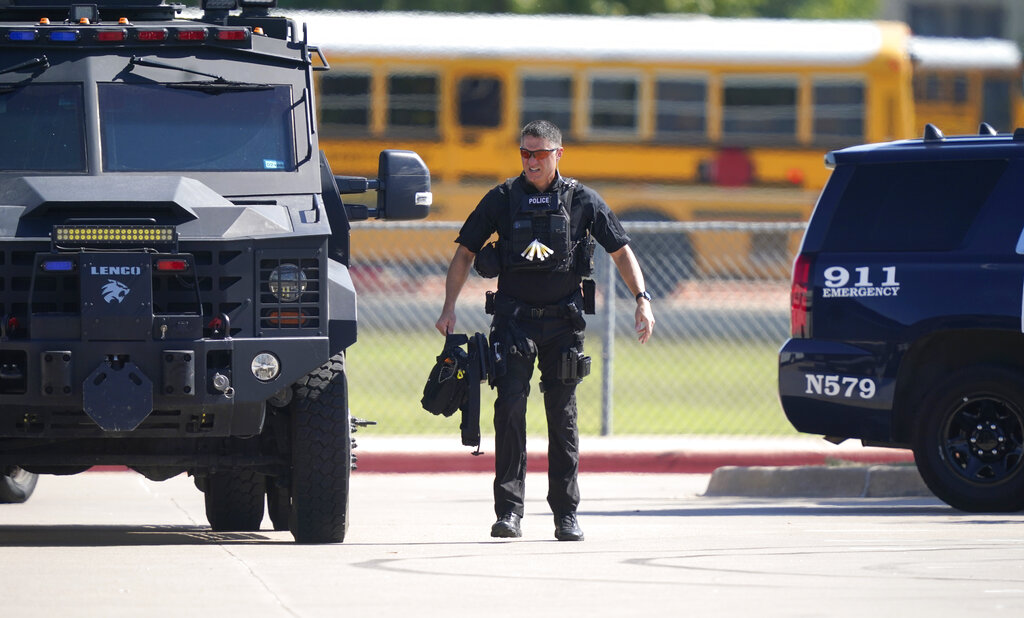 A law enforcement officer walks in the parking lot of Timberview Hight School after a shooting inside the school in south Arlington, Texas, Wednesday, Oct. 6, 2021.