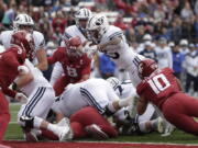 BYU running back Tyler Allgeier, top center, reaches for a touchdown during the second half of an NCAA college football game against Washington State, Saturday, Oct. 23, 2021, in Pullman, Wash. BYU won 21-19.