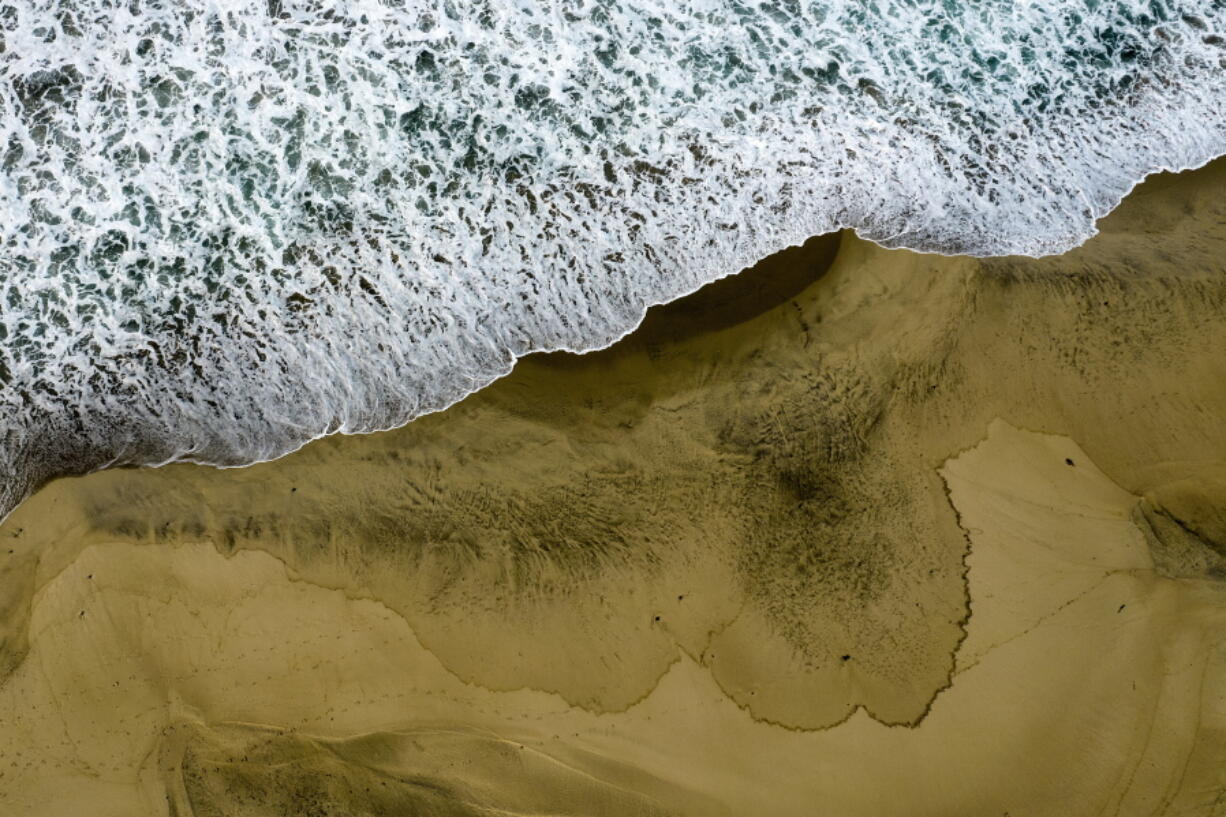 An aerial photo shows the closed beach after oil washed up on Huntington Beach, Calif., on Monday, Oct. 4, 2021. A major oil spill off the coast of Southern California fouled popular beaches and killed wildlife while crews scrambled Sunday, to contain the crude before it spread further into protected wetlands. (AP Photo/Ringo H.W. Chiu) (Ringo H.W.