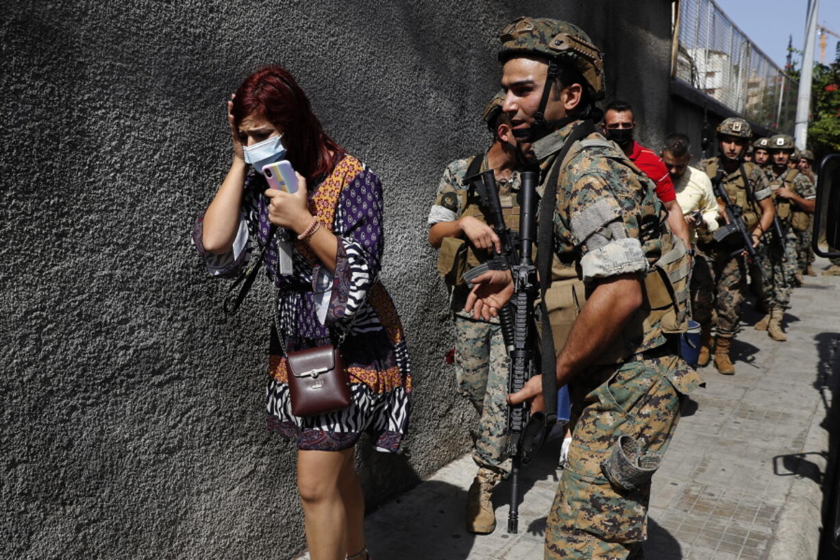 Lebanese army special forces soldiers protect teachers as they flee their school after deadly clashes erupted along a former 1975-90 civil war front-line between Muslim Shiite and Christian areas, at Ain el-Remaneh neighborhood, in Beirut, Lebanon, Thursday, Oct. 14, 2021. Armed clashes broke out in Beirut Thursday during the protest against the lead judge investigating last year's massive blast in the city's port, as tensions over the domestic probe boiled over.