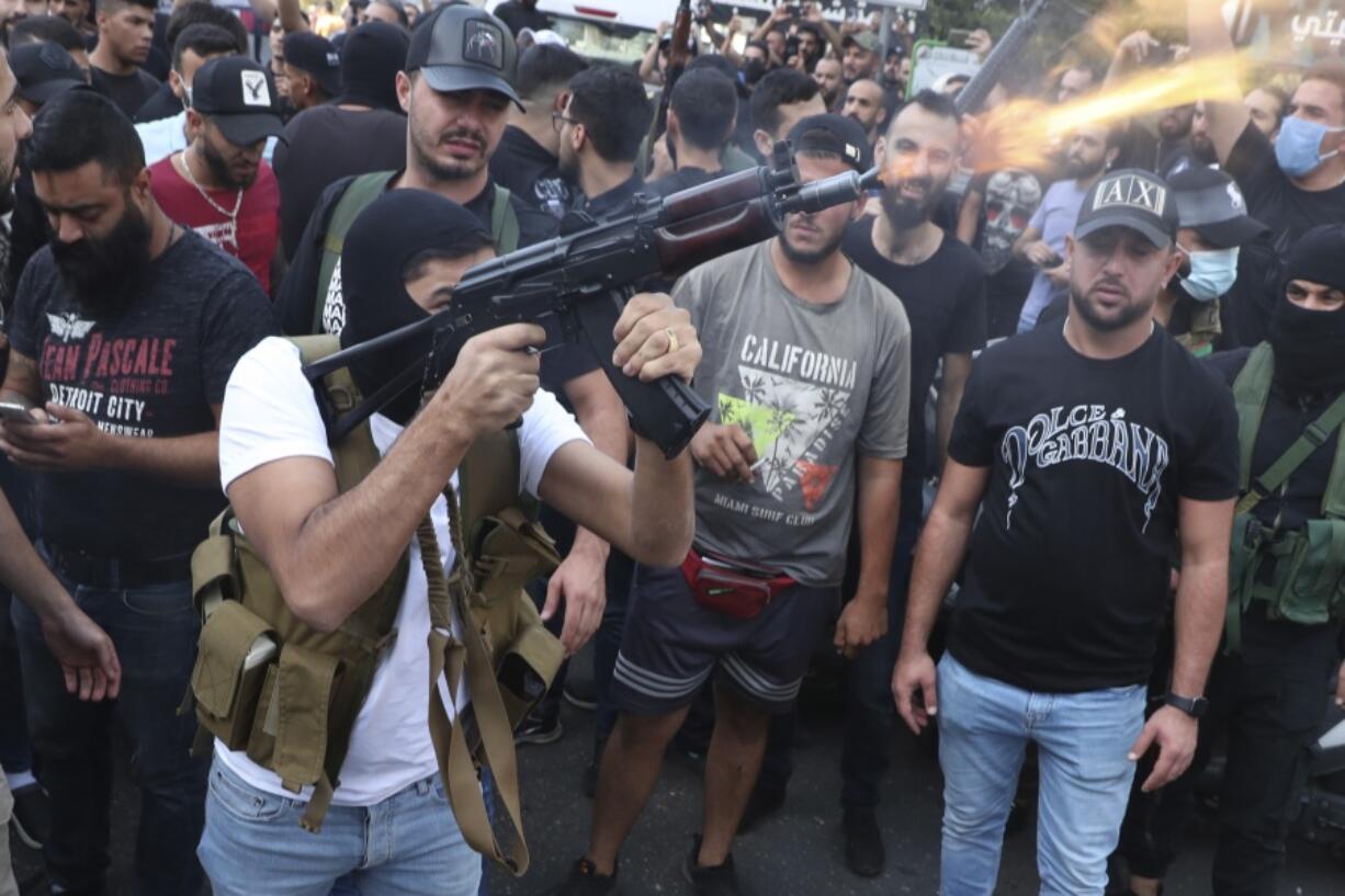 Supporters of the Shiite Amal group fire weapons in the air during the funeral processions of Hassan Jamil Nehmeh, who was killed during yesterday clashes, in the southern Beirut suburb of Dahiyeh, Lebanon, Friday, Oct. 15, 2021. Dozens of gunmen opened fire in the air Friday south of Beirut during the funeral of persons killed in hours of gun battles between heavily armed gunmen the day before that left several people dead and terrorized the residents of Beirut.