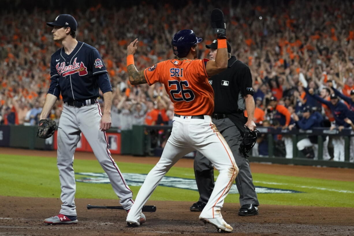 Houston Astros' Jose Siri celebrates past Atlanta Braves starting pitcher Max Fried on a throwing error during the second inning in Game 2 of baseball's World Series between the Houston Astros and the Atlanta Braves Wednesday, Oct. 27, 2021, in Houston.