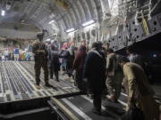 FILE - In this Aug. 22, 2021, file photo provided by the U.S. Air Force, Afghan passengers board a U.S. Air Force C-17 Globemaster III during the Afghanistan evacuation at Hamid Karzai International Airport in Kabul, Afghanistan. An Afghan man who worked for the U.S. government in Afghanistan says the Biden administration has ignored his pleas for help to evacuate his two young sons from Afghanistan after their mother died of a heart attack while being threatened by the Taliban. The International Refugee Assistance Project on Thursday, Oct. 7, 2021 filed a lawsuit against Secretary of State Antony Bilken on the man's behalf. The father fears for his children's safety and asked that he be identified only by his first name, Mohammad. (MSgt. Donald R. Allen/U.S.