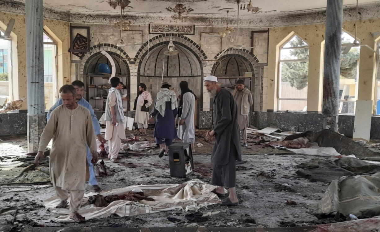 People view the damage inside of a mosque following a bombing in Kunduz, province northern Afghanistan, Friday, Oct. 8, 2021. A powerful explosion in the mosque frequented by a Muslim religious minority in northern Afghanistan on Friday has left several casualties, witnesses and the Taliban's spokesman said.