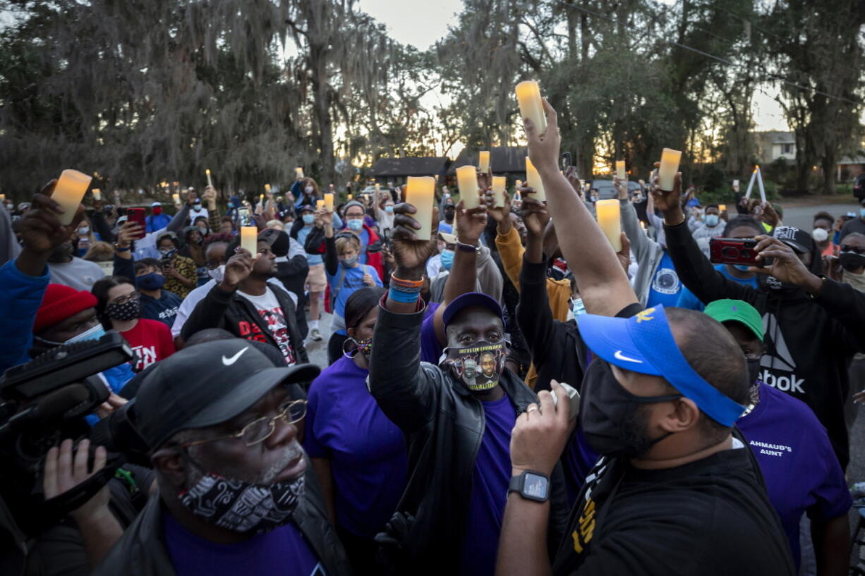 FILE - In this Feb. 23, 2021, file photo, Ahmaud Arbery's father, Marcus Arbery, bottom center, listens to Jason Vaughn speak during a memorial walk and candlelight vigil for Ahmaud at the Satilla Shores development in Brunswick, Ga. Arbery's son was shot and killed while running in a neighborhood outside the port city. Jury selection in the case is scheduled to begin Monday, Oct. 18. (AP Photo/Stephen B.