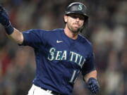 Seattle Mariners' Mitch Haniger motions toward his dugout as he begins to round the bases on his two-run home run against the Los Angeles Angels in the fifth inning of a baseball game Saturday, Oct. 2, 2021, in Seattle.