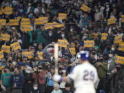 Seattle Mariners fans hold "Believe" signs as Seattle Mariners' Cal Raleigh bats against the Los Angeles Angels on Sunday in Seattle. (Ted S.