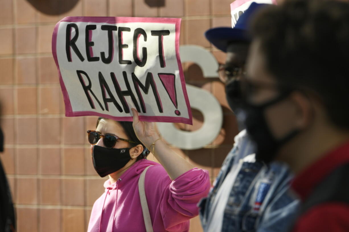 Danaka Katovich of Code Pink, holds a sign during a rally to protest former Chicago Mayor Rahm Emanuel's ambassador to Japan appointment outside the Chicago Police Headquarters Tuesday, Oct. 19, 2021, in Chicago. The fatal police shooting of a Black teen in Chicago seven years ago is looming large over the city's former mayor, Emanuel, as he looks to win confirmation as President Joe Biden's ambassador to Japan.