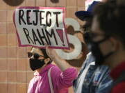 Danaka Katovich of Code Pink, holds a sign during a rally to protest former Chicago Mayor Rahm Emanuel's ambassador to Japan appointment outside the Chicago Police Headquarters Tuesday, Oct. 19, 2021, in Chicago. The fatal police shooting of a Black teen in Chicago seven years ago is looming large over the city's former mayor, Emanuel, as he looks to win confirmation as President Joe Biden's ambassador to Japan.