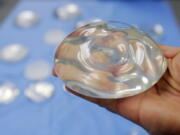 FILE - In this Dec. 11, 2006 file photo, a silicone gel breast implant is shown at Mentor Corp., a subsidiary of Johnson & Johnson, in Irving, Texas. On Wednesday, Oct. 27, 2021, U.S. health regulators finalized stronger warnings for breast implants, including a new requirement that people receive detailed information about their potential risks and complications before getting them.