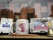 Windsor Castle is reflected in the window of a shop selling Royal souvenirs outside the Castle, in Windsor, England, Friday, Oct. 22, 2021. Britain's Queen Elizabeth II spent a night in a hospital for checks this week after canceling an official trip to Northern Ireland on medical advice, Buckingham Palace said Thursday. The palace said the 95-year-old British monarch went to the private King Edward VII's Hospital in London on Wednesday for "preliminary investigations." It said she returned to her Windsor Castle home at lunchtime on Thursday, "and remains in good spirits.