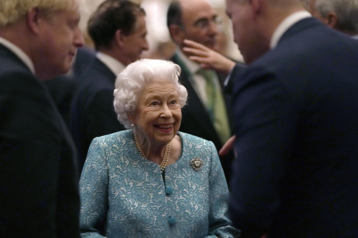 Britain's Queen Elizabeth II and Prime Minister Boris Johnson, left, greet guests at a reception for the Global Investment Summit in Windsor Castle, Windsor, England, Tuesday, Oct. 19, 2021.