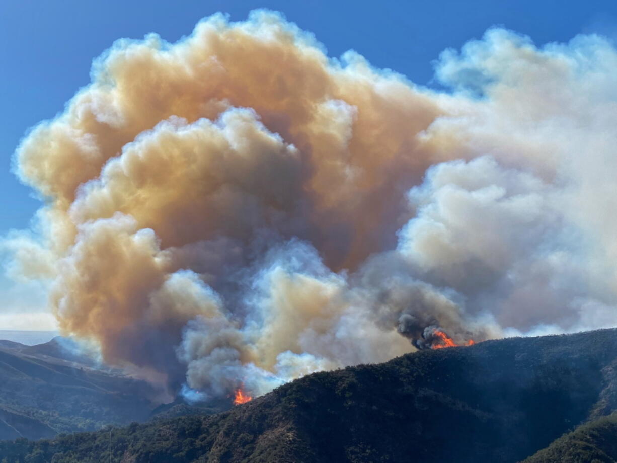 In this photo provided by Santa Barbara County Fire Department, the Alisal Fire continues to burn the dry vegetation in Refugio Canyon on Tuesday morning, Oct. 12, 2021,  in Santa Barbara County, Calif.