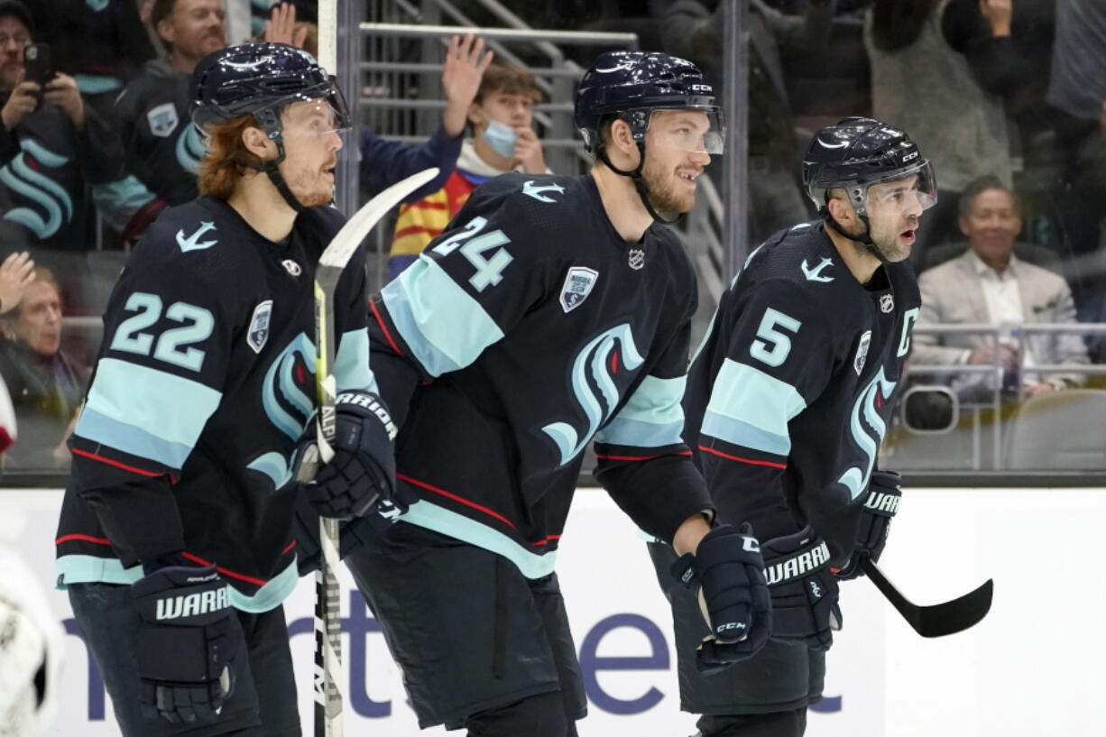 Seattle Kraken defenseman Jamie Oleksiak (24) reacts with teammates Mason Appleton (22) and Mark Giordano (5) after Oleksiak assisted Kraken's Brandon Tanev on a goal scored against the Montreal Canadiens during the first period of an NHL hockey game, Tuesday, Oct. 26, 2021, in Seattle. (AP Photo/Ted S.