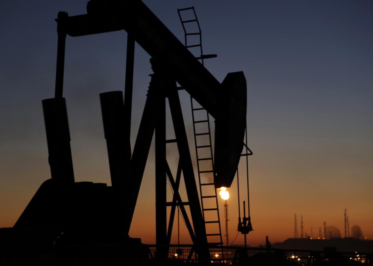 FILE - In this Jan. 18, 2016 file photo, an oil pump works at sunset, in the desert oil fields of Sakhir, Bahrain. The global energy transition is perhaps nowhere more perplexing than in the Arabian Peninsula. The political stability of the six Gulf states -- Saudi Arabia, the United Arab Emirates, Qatar, Kuwait, Bahrain and Oman -- is rooted in profits from fossil fuels. They are privately and publicly advocating for carbon capture technologies rather than a rapid phasing out of burning fossil fuels.