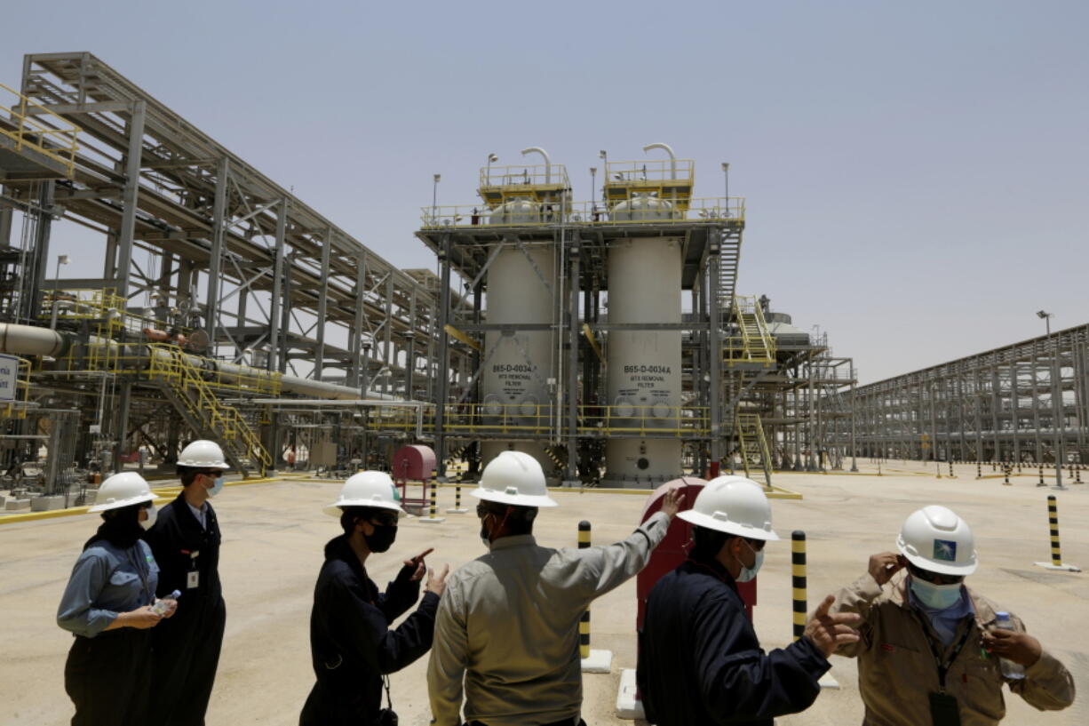 FILE - In this June 28, 2021, file photo, Saudi Aramco engineers and journalists look at the Hawiyah Natural Gas Liquids Recovery Plant in Hawiyah, in the Eastern Province of Saudi Arabia. One of the world's largest oil producers, Saudi Arabia, announced on Saturday, Oct. 23,  it aims to reach "net zero" greenhouse gas emissions by 2060, joining more than 100 countries in a global effort to try and curb man-made climate change.