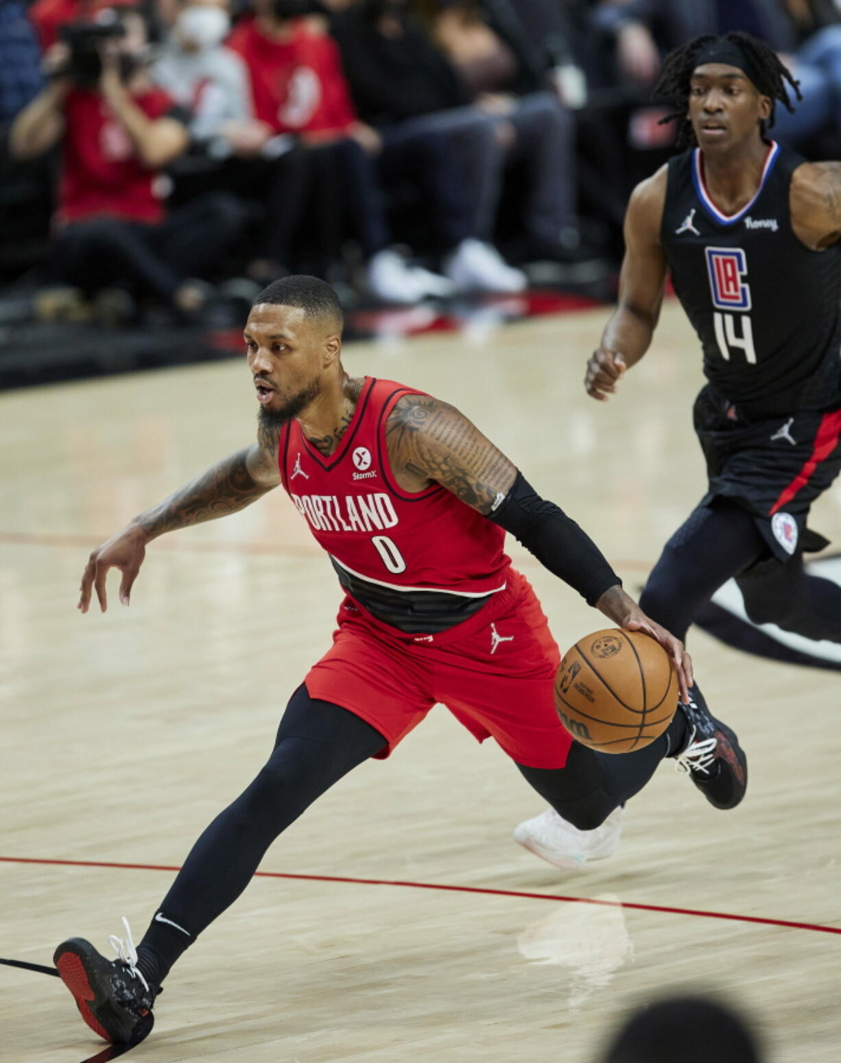 Portland Trail Blazers guard Damian Lillard, left, drives to the basket in front of Los Angeles Clippers guard Terance Mann during the first half of an NBA basketball game in Portland, Ore., Friday, Oct. 29, 2021.