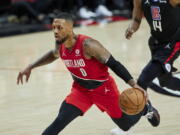 Portland Trail Blazers guard Damian Lillard, left, drives to the basket in front of Los Angeles Clippers guard Terance Mann during the first half of an NBA basketball game in Portland, Ore., Friday, Oct. 29, 2021.