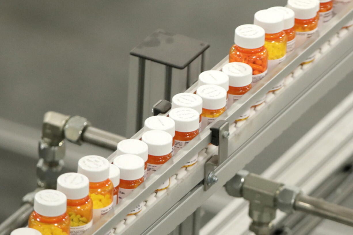 FILE- In this July 10, 2018 file photo, bottles of medications ride on a belt at a mail-in pharmacy warehouse in Florence, N.J. According to a study published Wednesday, Sept. 29, 2021 in the New England Journal of Medicine, British patients with a long history of depression highlights how difficult it can be to stop medication, even for those who feel well enough to try.