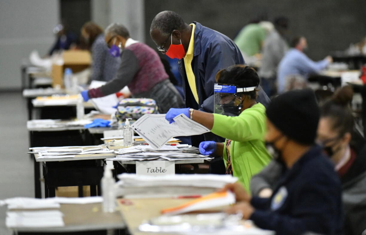 FILE - In this Saturday, Nov. 14, 2020, file photo, election workers in Fulton County began working through a recount of ballots in Atlanta. Investigators with Georgia's secretary of state's office have not found any evidence to substantiate claims that fraudulent or counterfeit ballots were counted in Fulton County during the 2020 general election. Henry County Superior Court Chief Judge Brian Amero is presiding over a lawsuit that alleges fraud in Fulton County during last year's election.