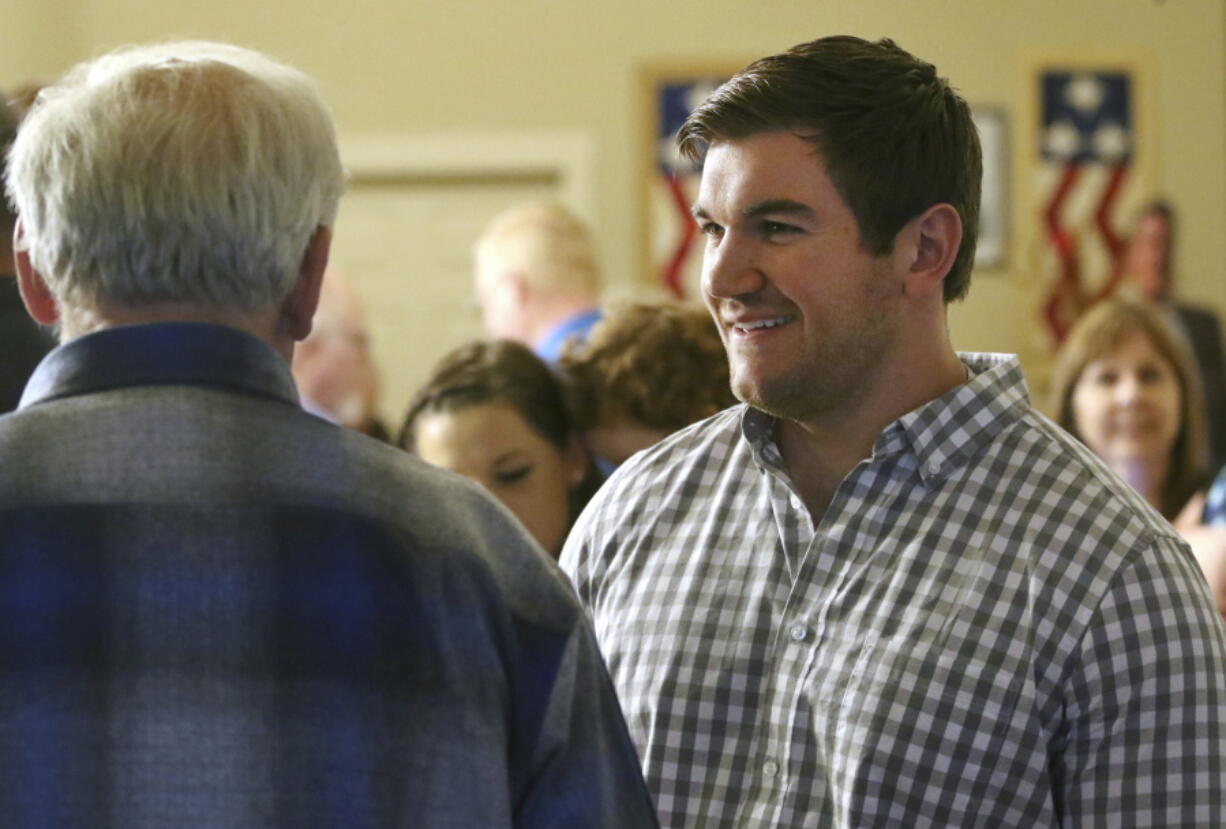 FILE - In this May 15, 2018 file photo, Alek Skarlatos, right, speaks at the Douglas County Republican Party headquarters in Roseburg, Ore. Oregon congressional candidate and hero soldier Skarlatos formed a nonprofit to advocate for veterans after he lost his 2020 race. The group has done little to advance that cause since then. But it has helped get the Republican's bid for a 2022 rematch with longtime Democratic Rep. Peter DeFazio off the ground.