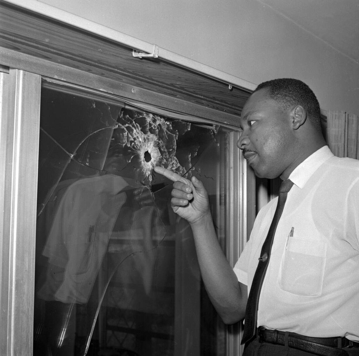 FILE - In this June 5, 1964, file photo, Dr. Martin Luther King Jr. looks at a glass door of his rented beach cottage in St. Augustine, Fla., that was shot into. The house connected to King  is now in the hands of a couple who plans to preserve it. David Manaute and Patti Barry live in the house on the coastline south of St. Augustine.