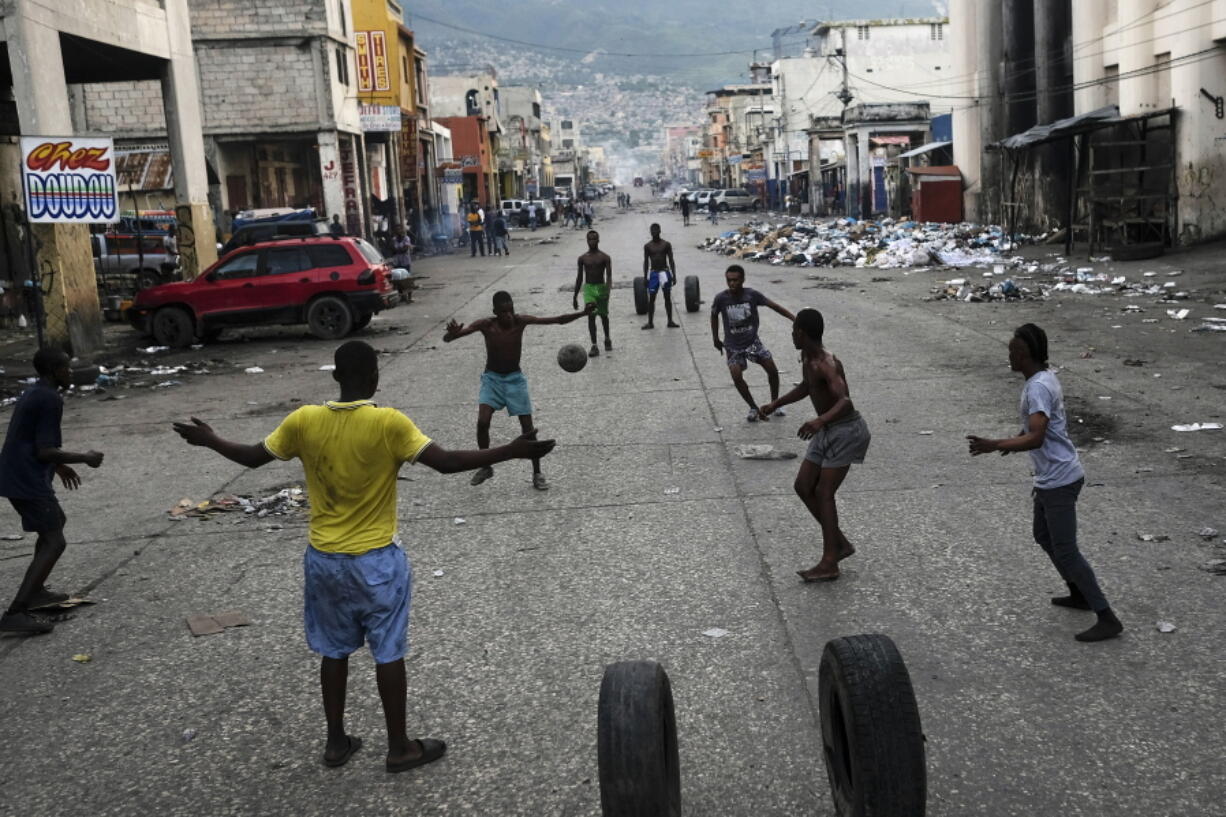 Youths play soccer next to businesses that are closed due to a general strike in Port-au-Prince, Haiti, Monday, Oct. 18, 2021. Workers angry about the nation's lack of security went on strike in protest two days after 17 members of a US-based missionary group were abducted by a violent gang.