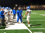 La Center football coach John Lambert, center, greets quarterback Darren Cepeda (7) after a scoring drive on Friday in a 61-14 win over Seton Catholic (Micah Rice/The Columbian)