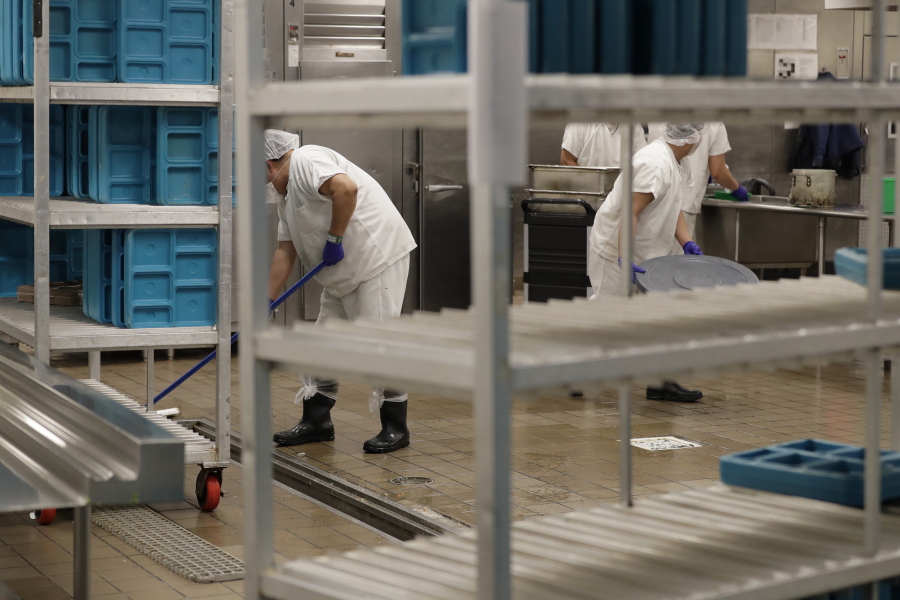 FILE - In this Sept. 10, 2019, workers are shown in the kitchen of the U.S. Immigration and Customs Enforcement (ICE) detention facility in Tacoma, Wash., during a media tour.  (AP Photo/Ted S.