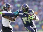 Seattle Seahawks' DK Metcalf (14) pushes off of Jacksonville Jaguars' Rayshawn Jenkins as he runs with the ball during the first half of an NFL football game, Sunday, Oct. 31, 2021, in Seattle. (AP Photo/Ted S.