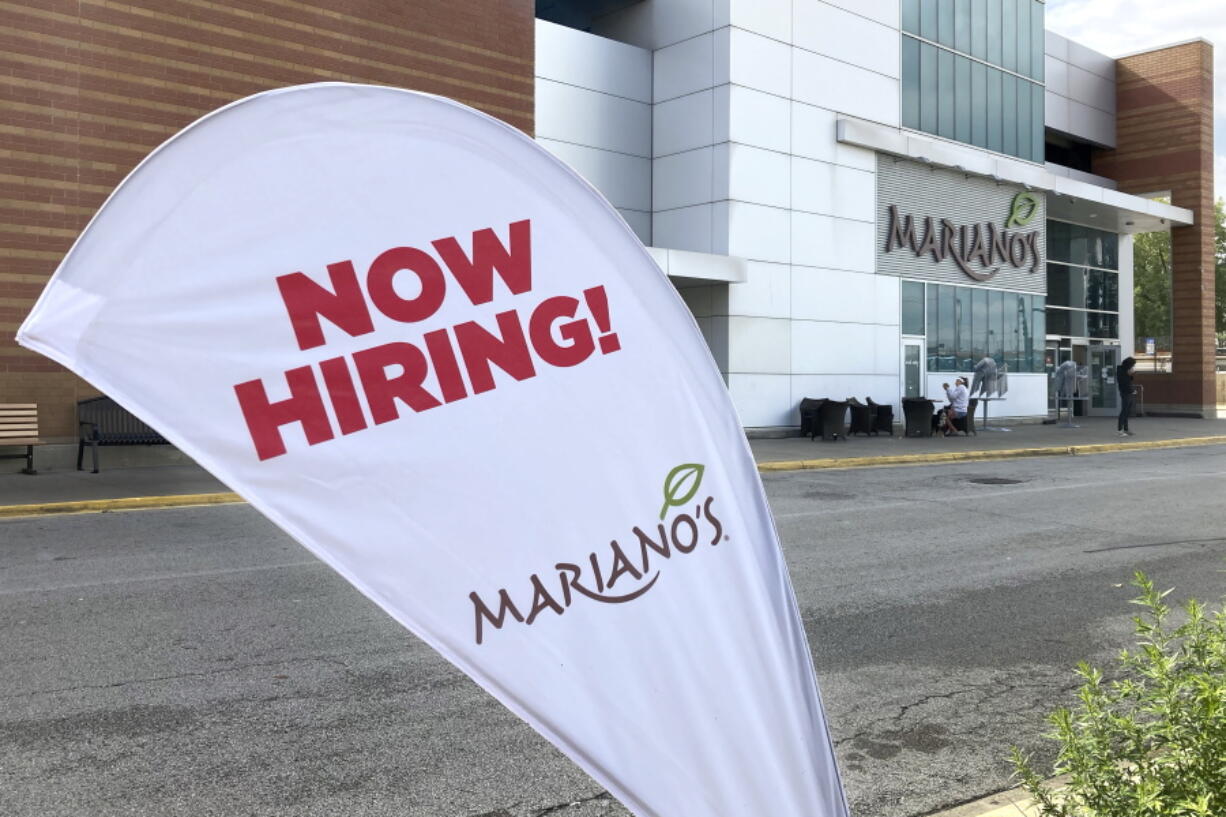 A sign in the parking lot of Mariano's grocery store advertises the availability of jobs Friday, Oct. 8, 2021, in Chicago.  One reason America's employers are having trouble filling jobs was starkly illustrated in a report Tuesday, Oct. 12: Americans are quitting in droves.