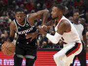 Sacramento Kings guard De'Aaron Fox, left, tries to get past Portland Trail Blazers guard Damian Lillard during the first half of an NBA basketball game in Portland, Ore., Wednesday, Oct. 20, 2021.