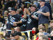 Seattle Kraken fans celebrate the team's goal against the Vegas Golden Knights during the second period of an NHL hockey game Tuesday, Oct. 12, 2021, in Las Vegas.