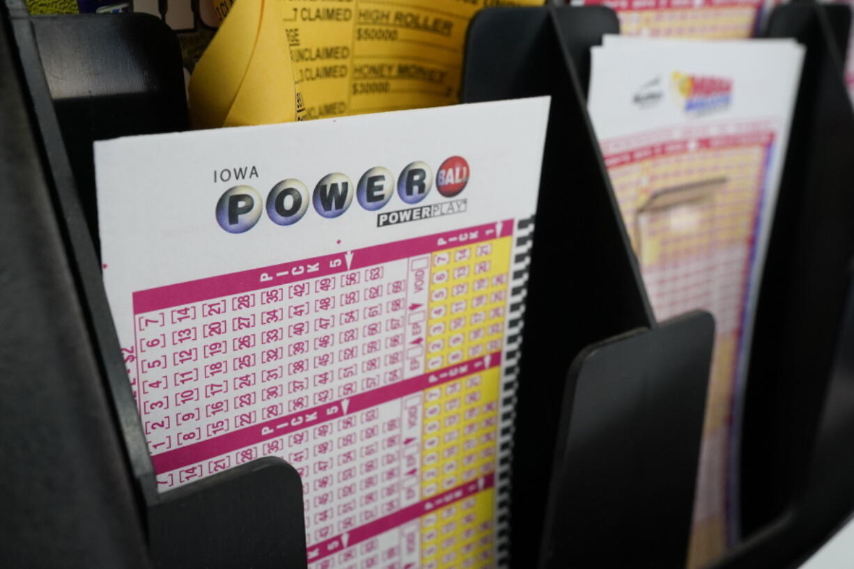 FILE - In this Jan. 12, 2021 file photo, blank forms for the Powerball lottery sit in a bin at a local grocery store, in Des Moines, Iowa.