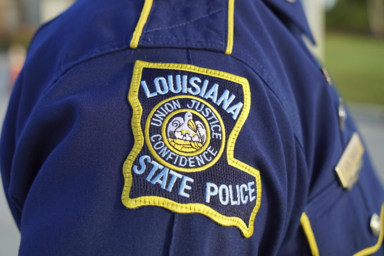 A Louisiana State Police trooper attends the funeral of a colleague in Baton Rouge, La., on Saturday, Oct. 16, 2021. As the Louisiana State Police reel from a sprawling federal investigation into the deadly 2019 arrest of Black motorist Ronald Greene and other beating cases, dozens of current and former troopers tell The Associated Press of an entrenched culture at the agency of impunity, nepotism and in some cases outright racism. (AP Photo/Allen G.