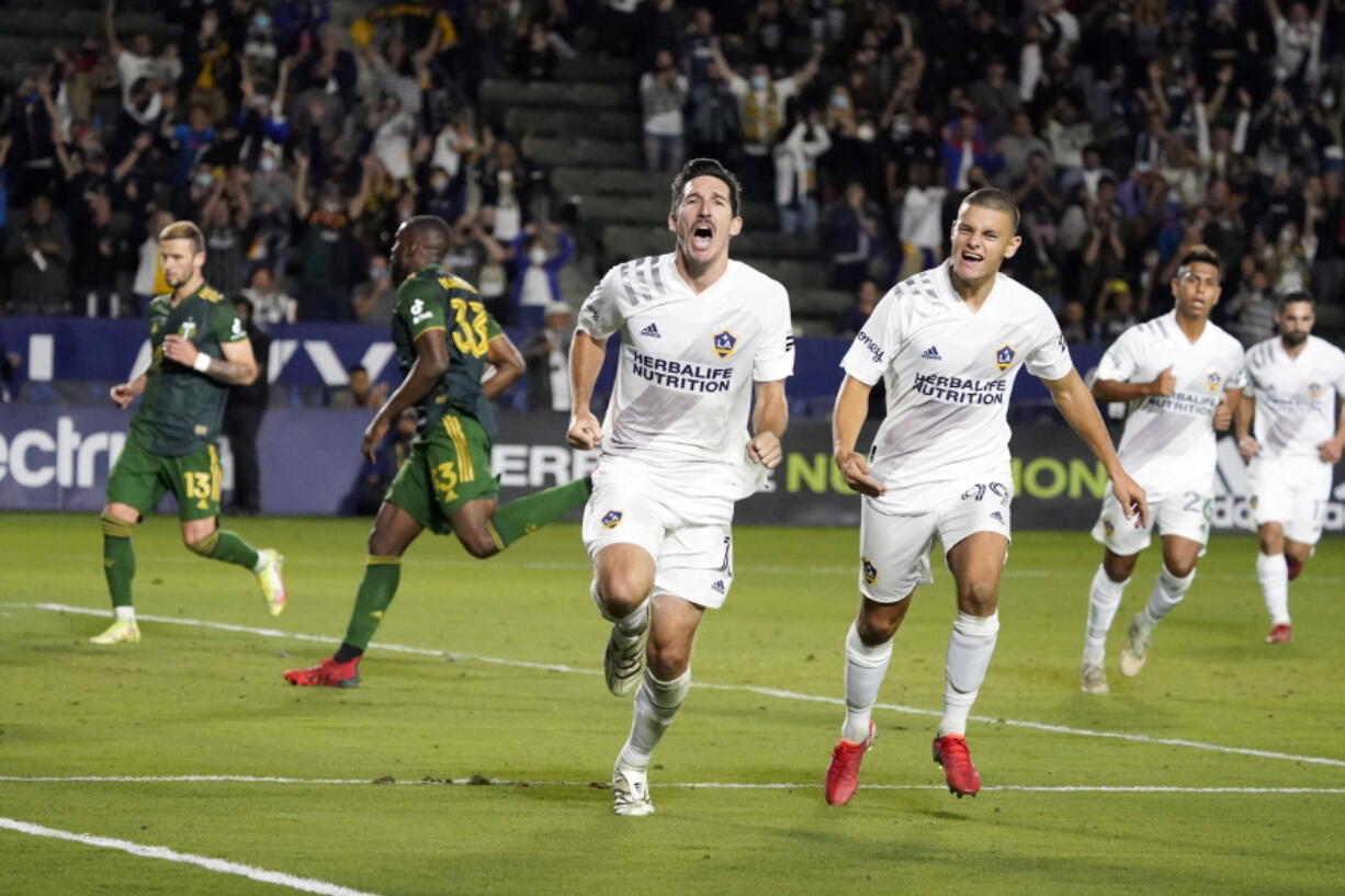 LA Galaxy midfielder Sacha Kljestan, center, celebrates after scoring on a penalty kick during the second half against the Portland Timbers in an MLS soccer match Saturday, Oct. 16, 2021, in Carson, Calif.