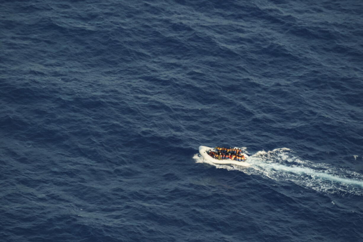 Migrants on an overcrowded rubber boat fleeing Libya navigate international waters in the Central Mediterranean Sea towards the Italian island of Lampedusa on Tuesday, Oct. 5, 2021. The unseaworthy boat was spotted by the Seabird, a monitoring aircraft operated by the Sea-Watch non-governmental organization, 60 nautical miles from Lampedusa as a storm approached the area. The fate of those onboard is not yet known.