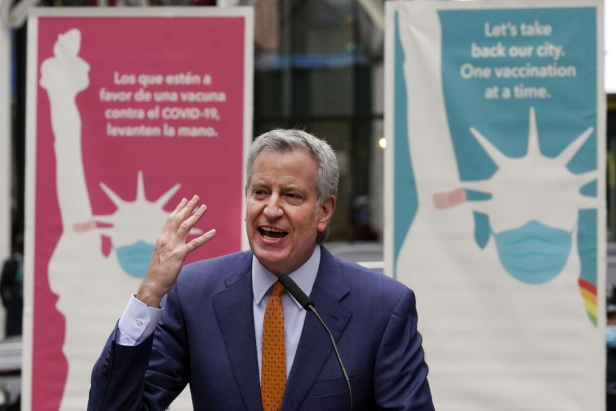 FILE - New York Mayor Bill de Blasio delivers his remarks in Times Square after he toured the grand opening of a Broadway COVID-19 vaccination site intended to jump-start the city's entertainment industry, in New York,  in this Monday, April 12, 2021, file photo. New York City will require police officers, firefighters and other municipal workers to be vaccinated against COVID-19 or be placed on unpaid leave, Mayor Bill de Blasio said Wednesday, Oct. 20, 2021, giving an ultimatum to public employees who've refused and ensuring a fight with some of the unions representing them.