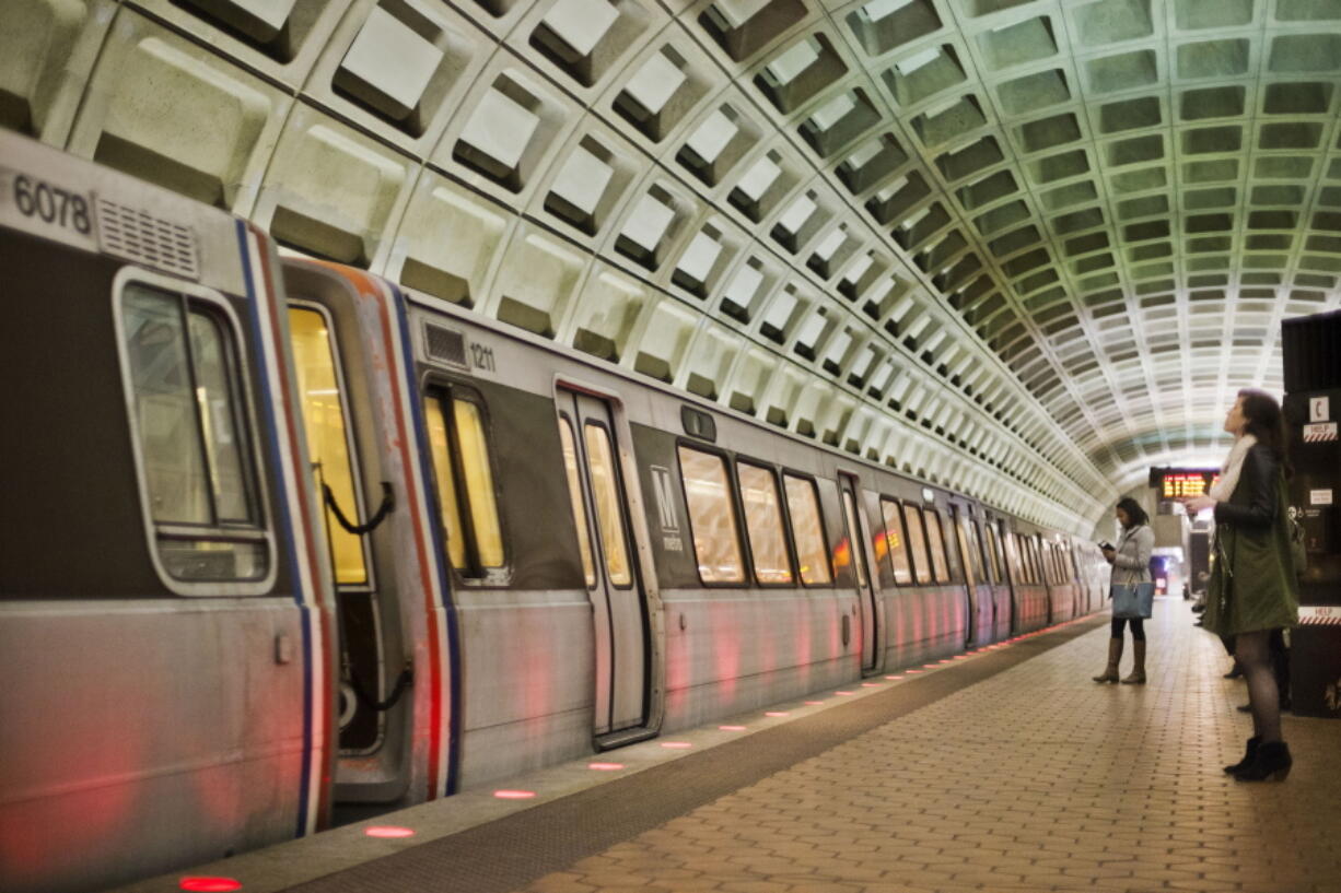 FILE - In this March 12, 2015 file photo, passengers wait on the platform before boarding a train at the U Street Metro Station in Washington, part of the public mass transit network for Washington. Washington's regional Metro system abruptly pulled more than half its fleet of trains from service early Monday morning over a lingering problem with the wheels and axles that caused a dramatic derailing last week.