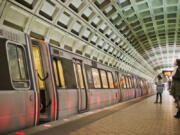 FILE - In this March 12, 2015 file photo, passengers wait on the platform before boarding a train at the U Street Metro Station in Washington, part of the public mass transit network for Washington. Washington's regional Metro system abruptly pulled more than half its fleet of trains from service early Monday morning over a lingering problem with the wheels and axles that caused a dramatic derailing last week.