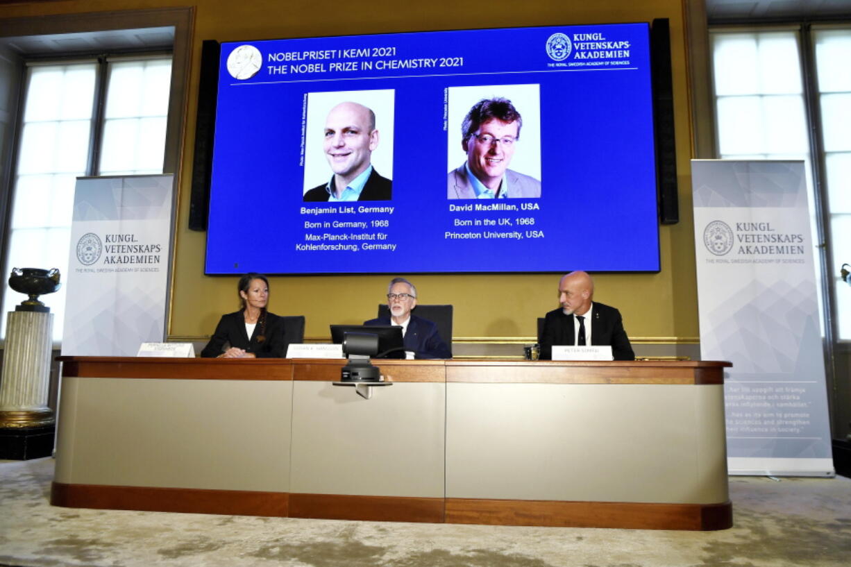 Goran K Hansson, Permanent Secretary of the Royal Swedish Academy of Sciences, centre, announces the winners of the 2021 Nobel Prize in Chemistry, in Stockholm, Sweden, Wednesday, Oct. 6, 2021. Professor Pernilla Wittung-Stafhede, is seated at left and  Professor Peter Somfai at right. Two scientists have won the Nobel Prize for chemistry for finding an "ingenious" new way to build molecules that can be used to make everything from medicines to food flavorings. Benjamin List of Germany and Scotland-born David W.C. MacMillan developed "asymmetric organocatalysis." Goran Hansson of the Royal Swedish Academy of Sciences said Wednesday that work has already had a significant impact on pharmaceutical research.