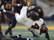 Oregon State running back B.J. Baylor (4) is tackled by California linebacker Marqez Bimage (46) during the first half of an NCAA college football game in Berkeley, Calif., Saturday, Oct. 30, 2021.