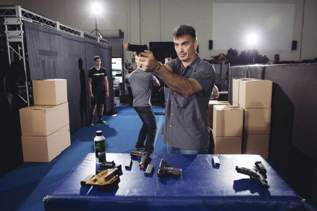 FILE - In this Oct. 7, 2014 photo, Chad Stahelski, co-director of the film, "John Wick," demonstrates proper gun handling during a training session at 87Eleven Action Design in Inglewood, Calif. Guns used in making movies are sometimes real weapons that can fire either bullets or blanks, which are gunpowder charges that produce a flash and a bang but no deadly projectile.