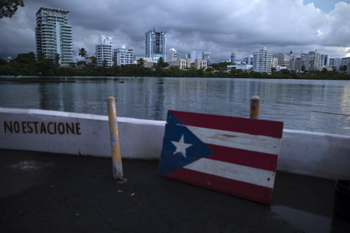 A wooden Puerto Rican flag is displayed on the dock of the Condado lagoon, where multiple selective blackouts have been recorded in the past days, in San Juan, Puerto Rico, Thursday, Sept. 30, 2021. Power outages across the island have surged in recent weeks, with some lasting up to several days.