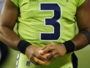 Seattle Seahawks quarterback Russell Wilson holds a sponge near his taped injured finger during the fourth quarter of an NFL football game against the Los Angeles Rams, Thursday, Oct. 7, 2021, in Seattle. Wilson left the game after the injury and the Rams won 26-17.