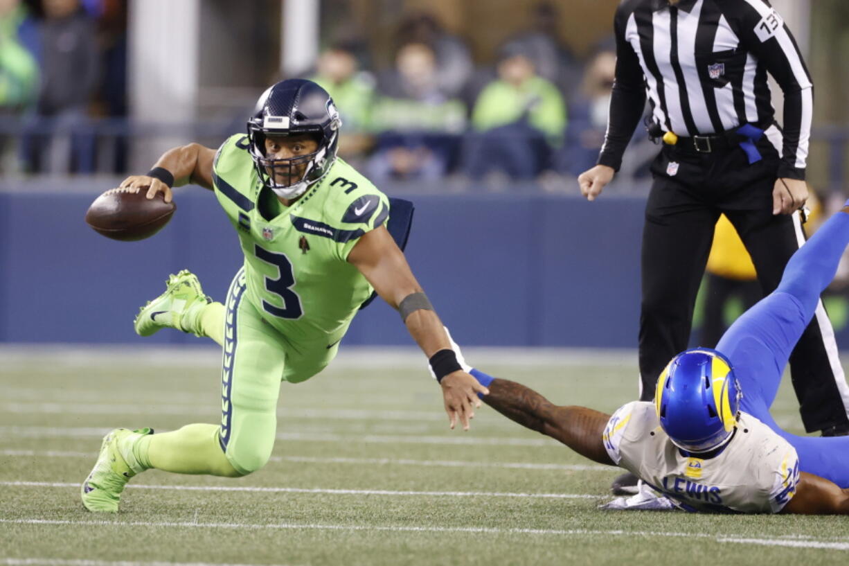 Seattle Seahawks quarterback Russell Wilson goes down as he tries to get a pass off against the Los Angeles Rams during the second half of an NFL football game, Thursday, Oct. 7, 2021, in Seattle.