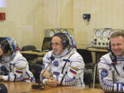 In this handout photo released by Roscosmos, actress Yulia Peresild, left, film director Klim Shipenko, right, and cosmonaut Anton Shkaplerov speak with their relatives through a safety glass prior the launch at the Baikonur Cosmodrome, Kazakhstan, Tuesday, Oct. 5, 2021. Actress Yulia Peresild and film director Klim Shipenko blasted off Tuesday for the International Space Station in a Russian Soyuz spacecraft together with cosmonaut Anton Shkaplerov, a veteran of three space missions, to make a feature film in orbit.