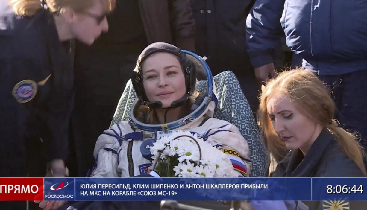 In this photo taken from video footage released by Roscosmos Space Agency, actress Yulia Peresild sits in a chair shortly after the landing of the Russian Soyuz MS-18 space capsule, southeast of the Kazakh town of Zhezkazgan, Kazakhstan, Sunday, Oct. 17, 2021. The Soyuz MS-18 capsule landed upright in the steppes of Kazakhstan on Sunday with cosmonaut Oleg Novitskiy, actress Yulia Peresild and film director Klim Shipenko aboard after a 3 1/2-hour trip from the International Space Station.